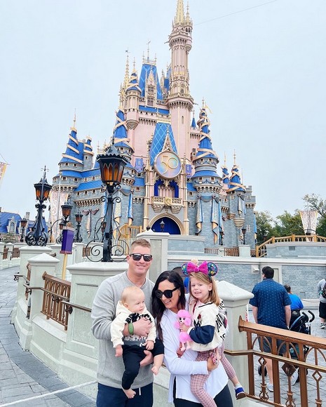  Một gia đình Việt Nam có trẻ nhỏ chụp ảnh trước cổng Disneyland California, phía sau là lâu đài cổ tích